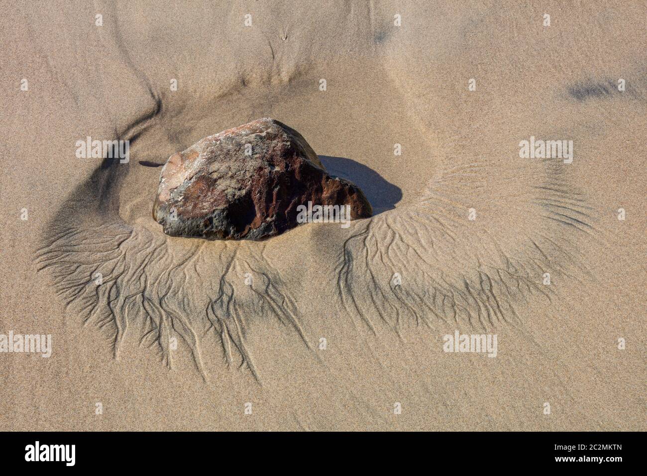 Sand pattern around a small rock from receding tide, Arcadia Beach State Wayside, Oregon Stock Photo