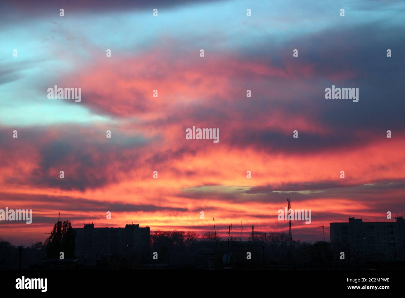 Crimson sunset above multistory house. Evening cityscape. City landscape. Dusk in town Stock Photo