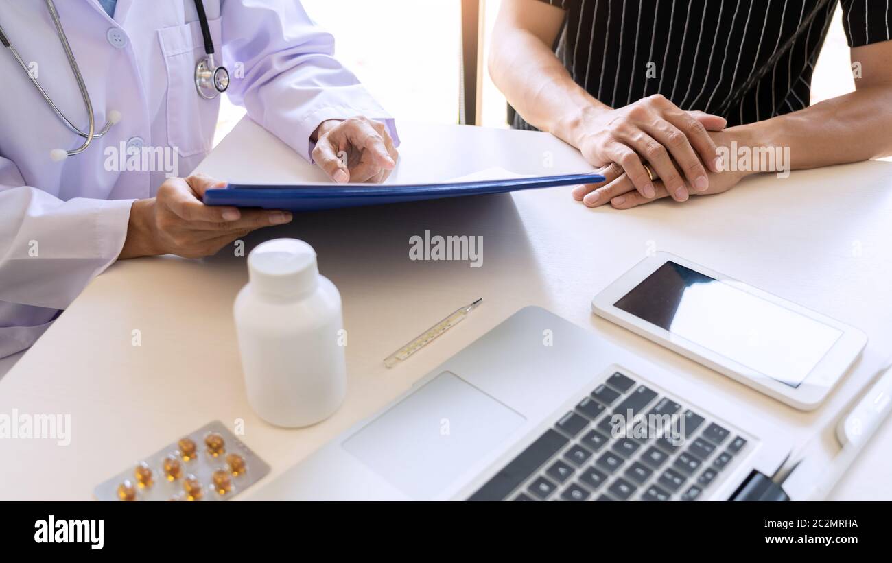 Doctor explaining for patient and showing medical records informations ...