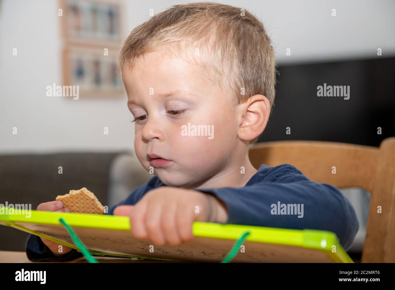 two year old boy eating a small cake Stock Photo