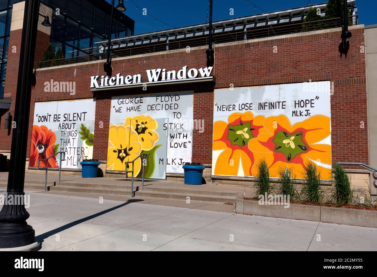 Statements of MLK illustrated with large flowers on three Kitchen Window boarded windows. Minneapolis Minnesota MN USA Stock Photo