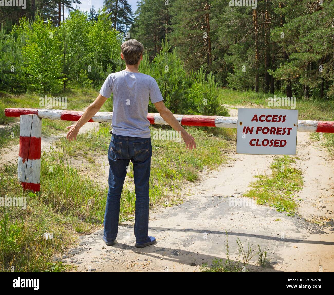 Man stands in front of a placard prohibiting Stock Photo