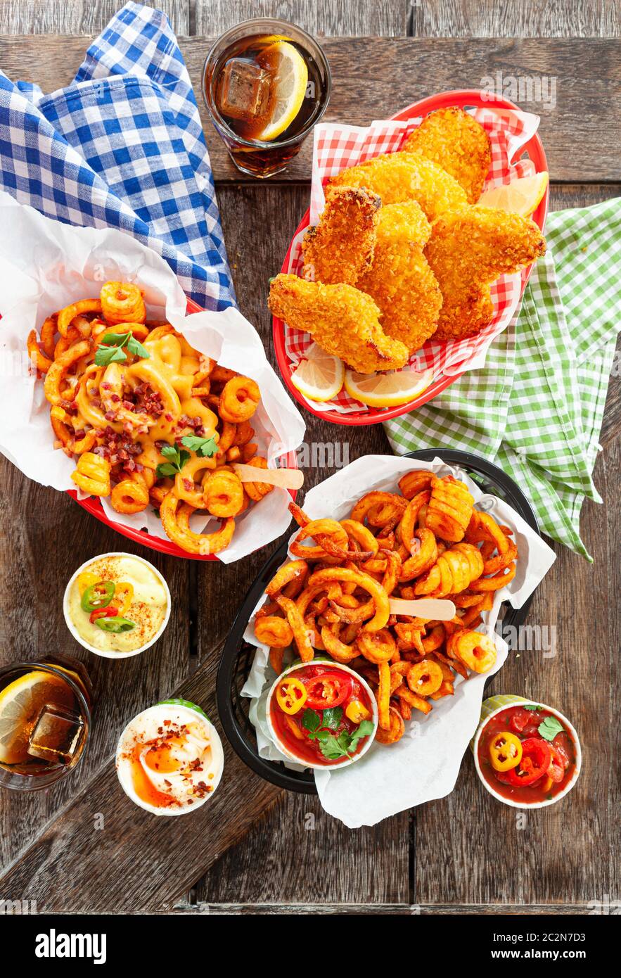 Tasty fast food with curly fries and fried chicken fingers Stock Photo
