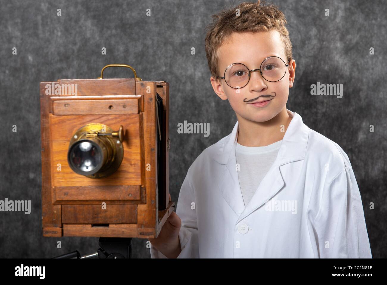 cheerful boy retro photographer with a vintage wooden camera Stock Photo