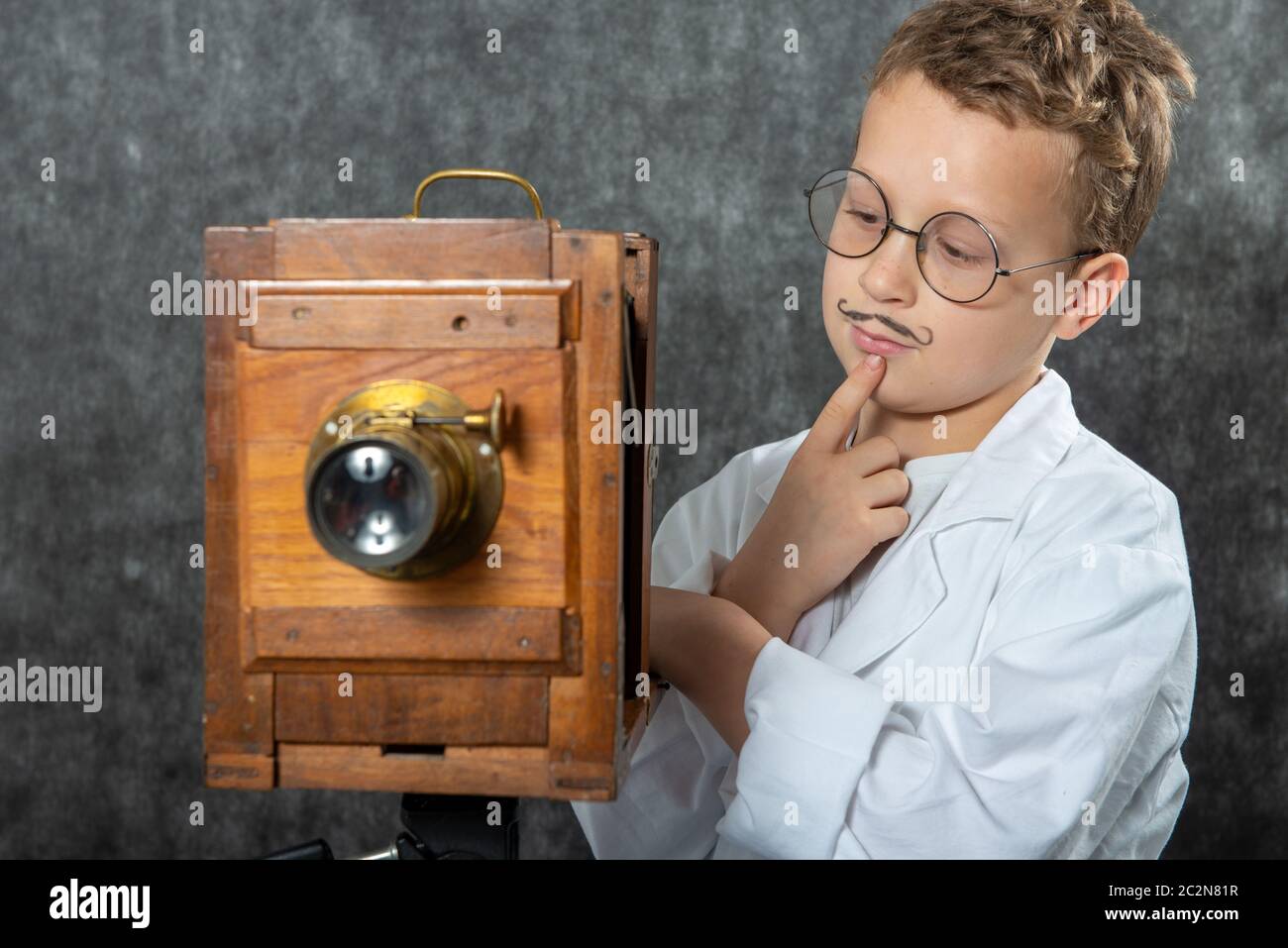 cheerful boy retro photographer with a vintage wooden camera Stock Photo