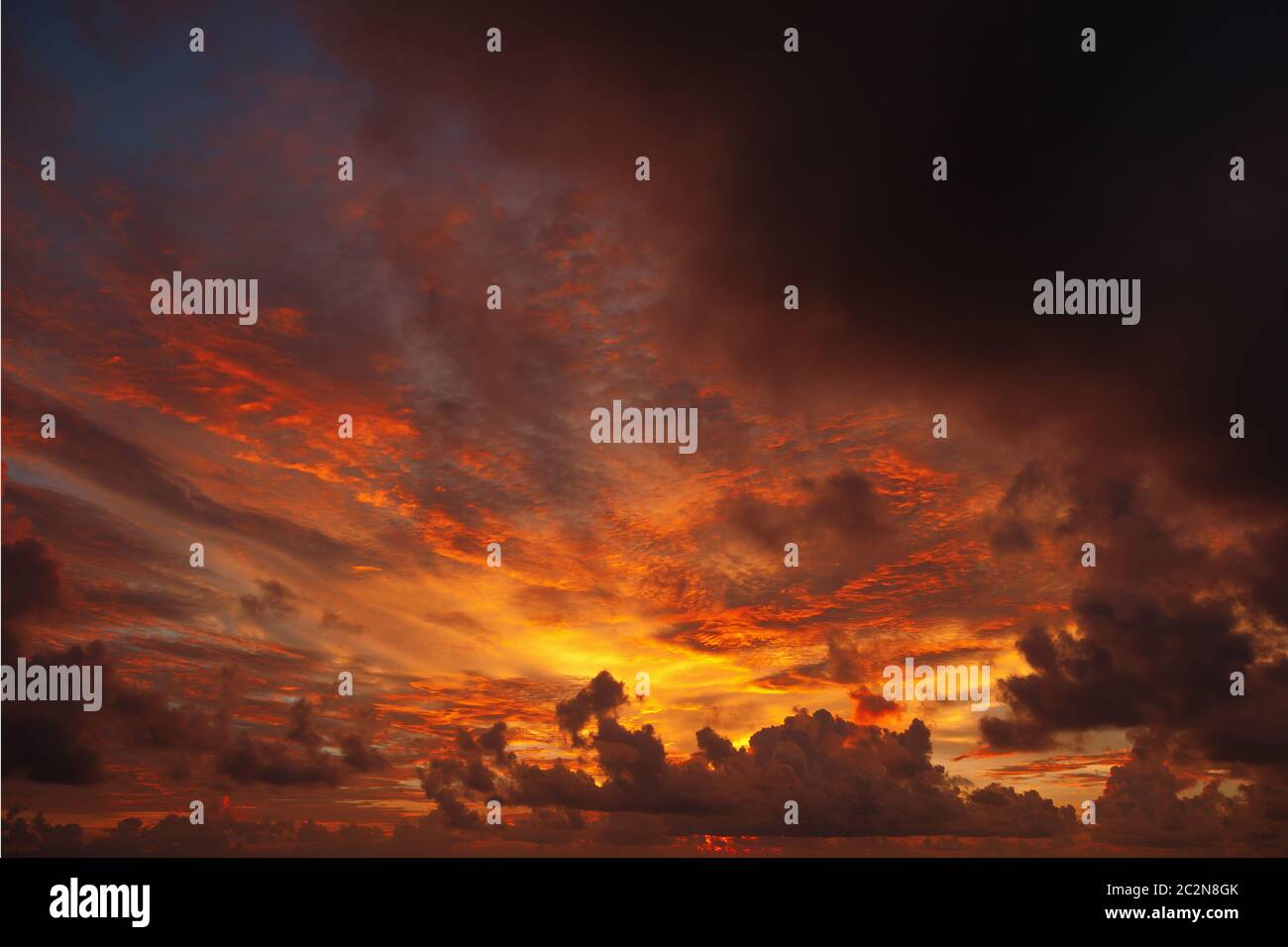 Ominous sunset , the sun paints the clouds red Stock Photo