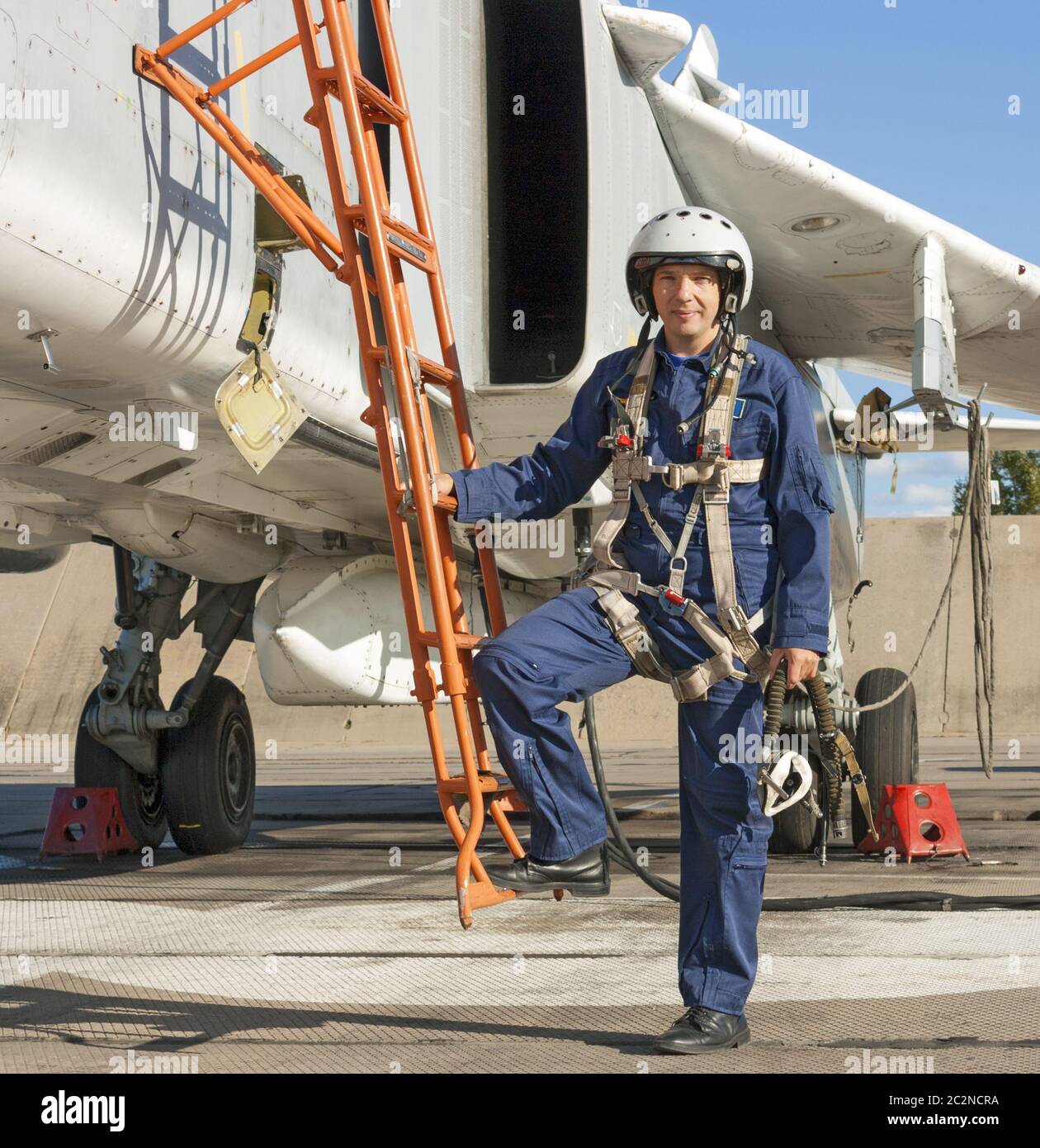 Military pilot in helmet stands near jet plane Stock Photo