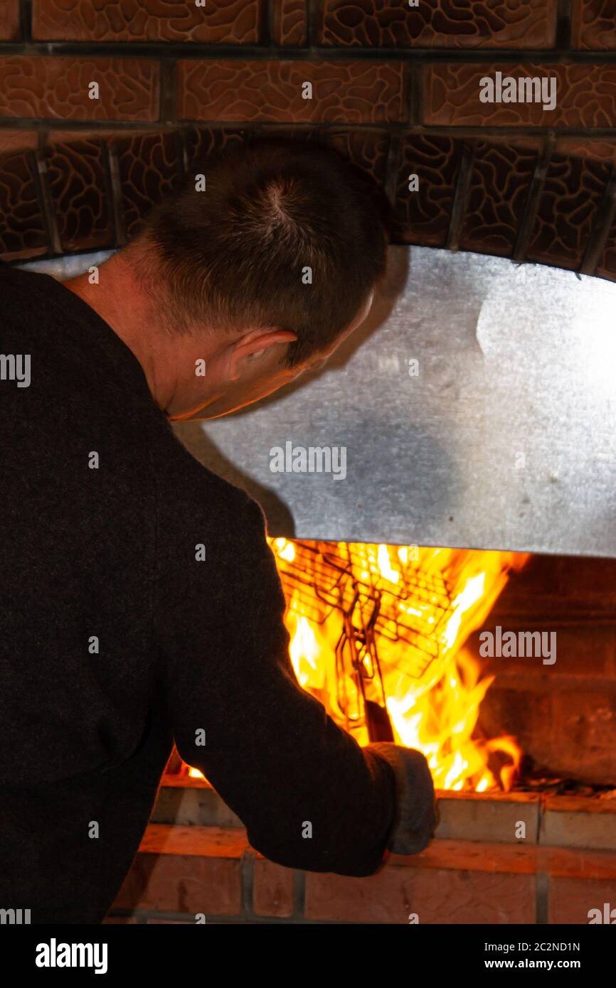 man is preparing barbecue meat on fire Stock Photo - Alamy