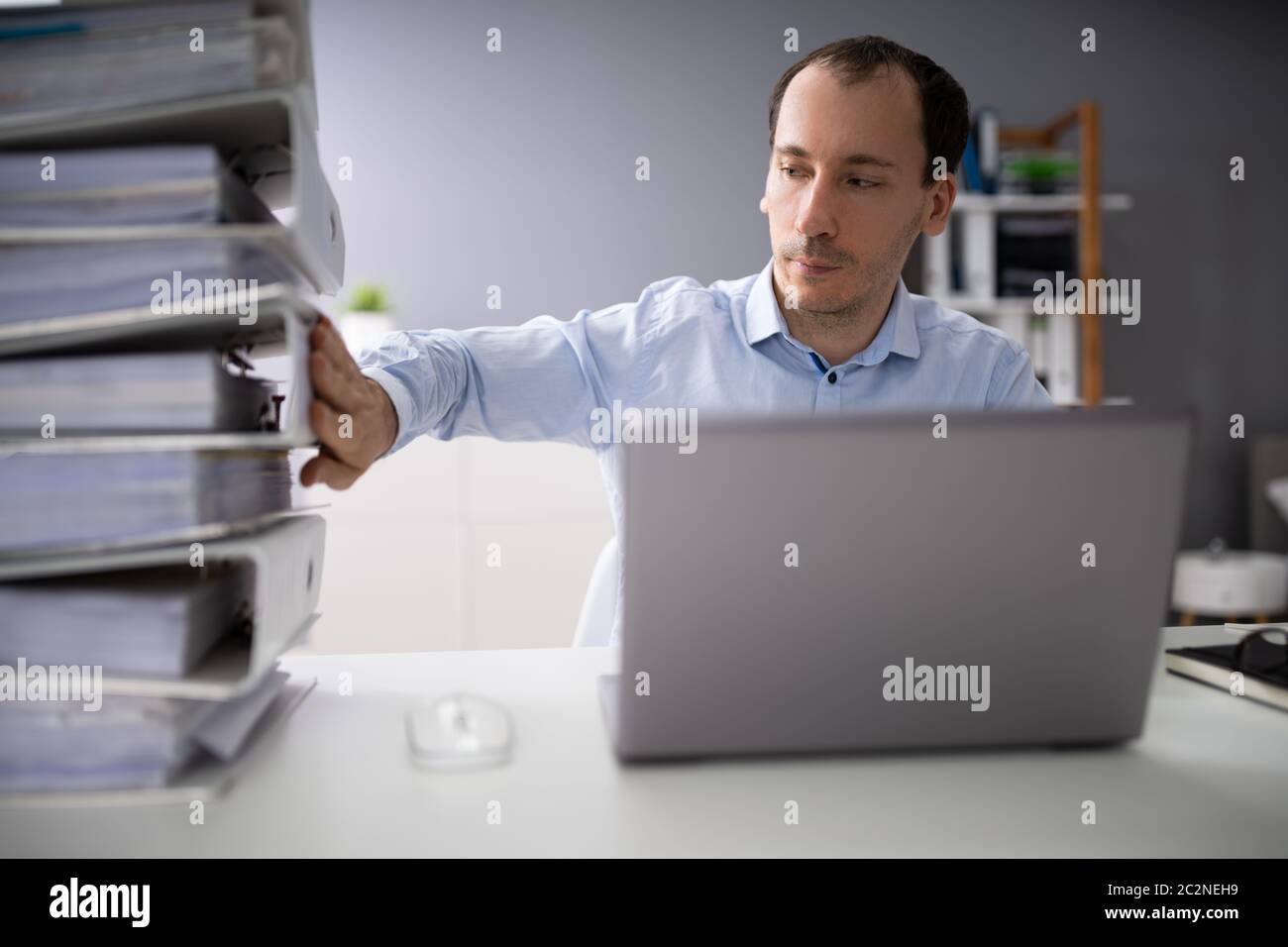 Businessperson Pushing Paper Documents Away And Working With Digital Documents On Computer Instead Stock Photo