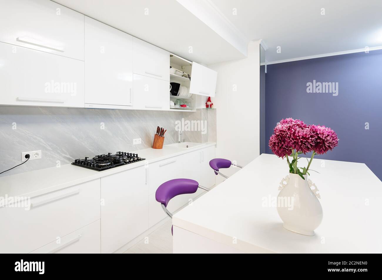 modern kitchen with dining table and purple chairs Stock Photo Alamy