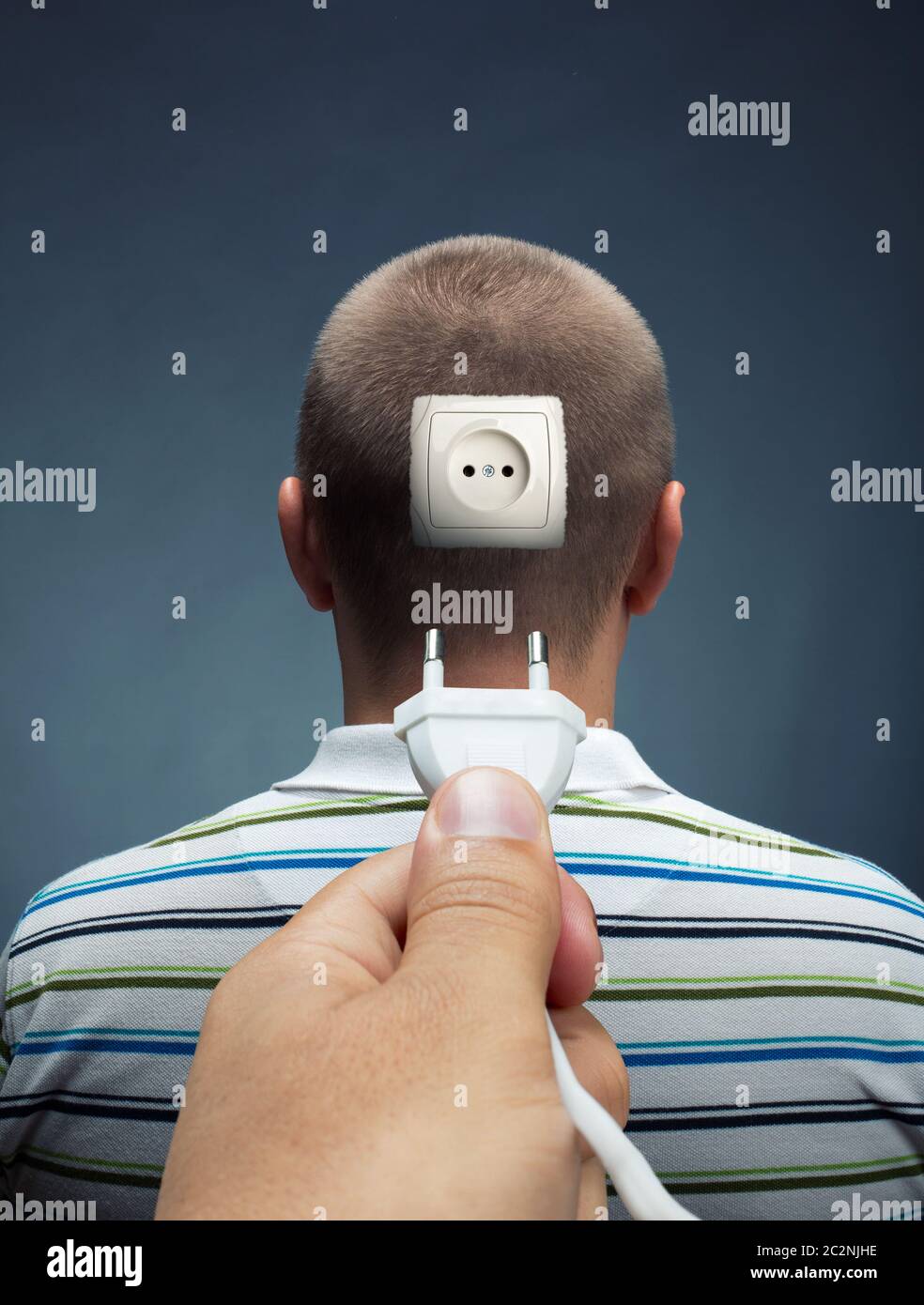 Plugging electrical cable into the outlet in head Stock Photo Alamy