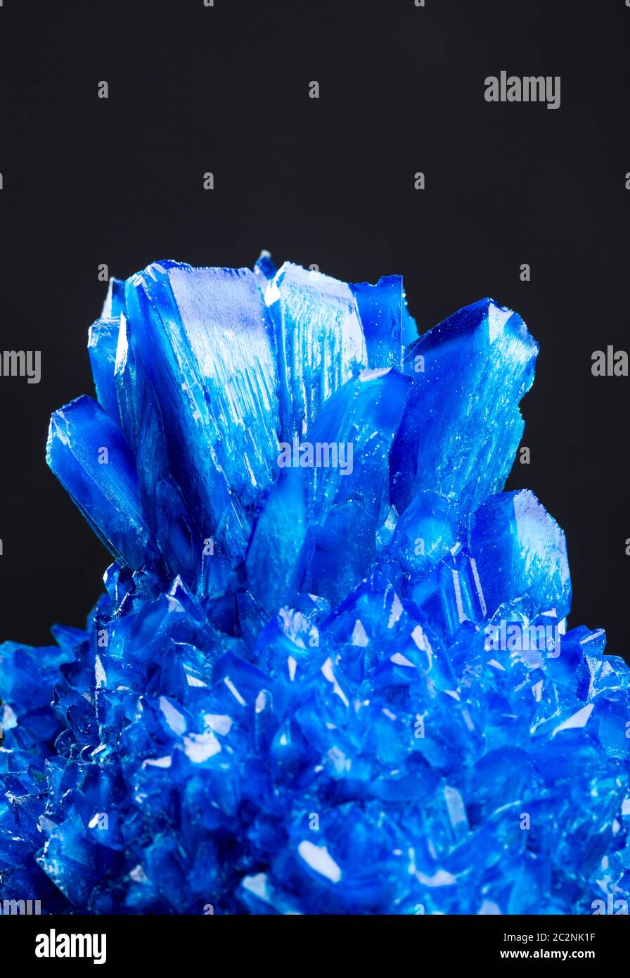 Blue salt crystal isolated on black background. Icy sulphate Stock
