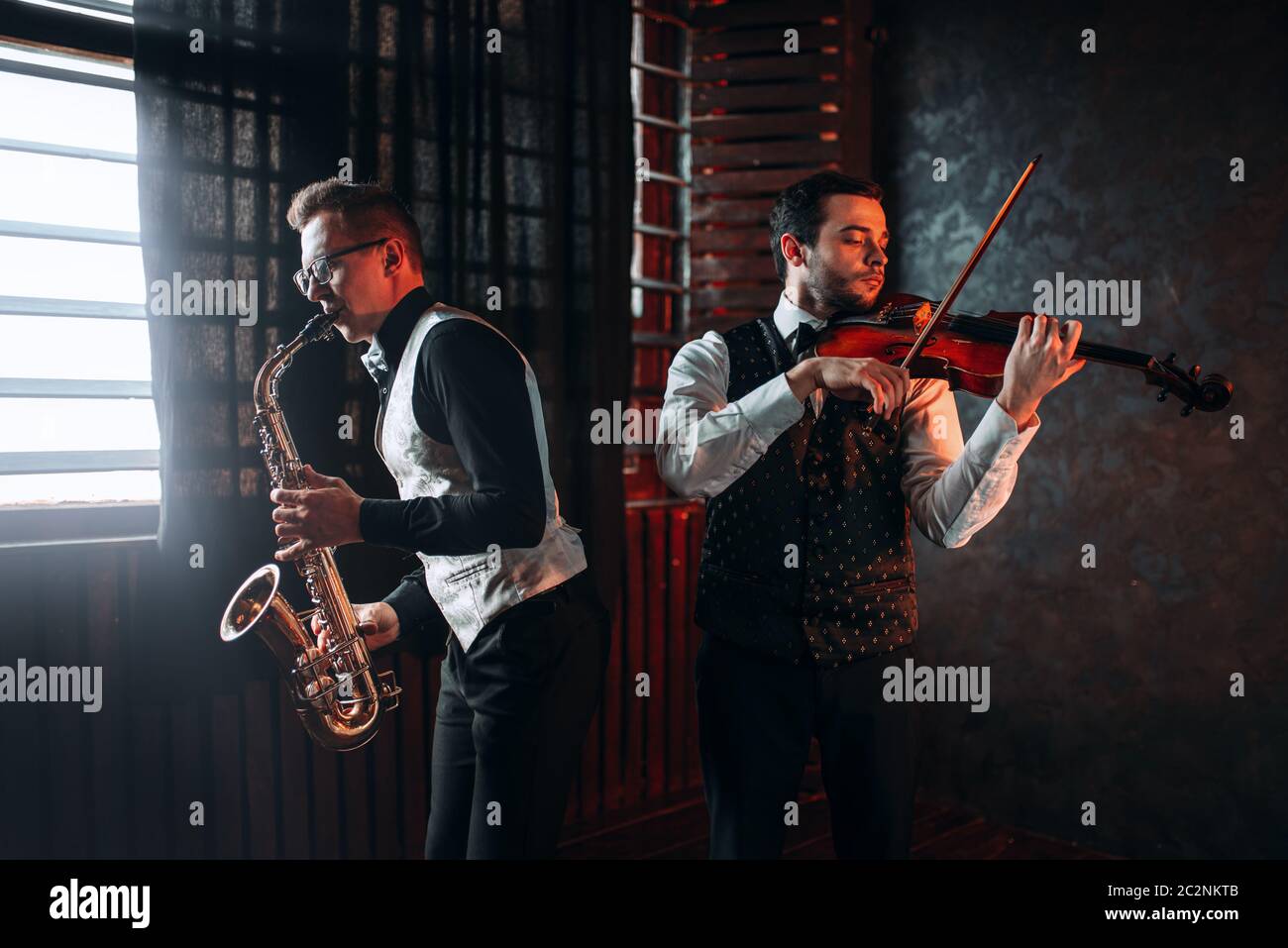 Sax man and fiddler duet playing classical melody. Jazz man and
