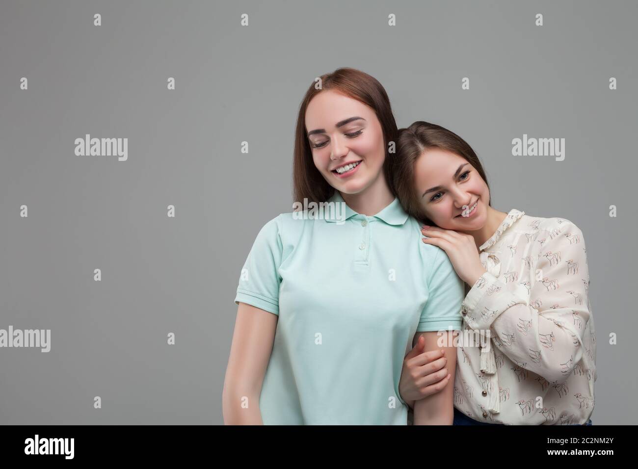 Two women hugs together, studio photo shoot. Female friendship Stock Photo