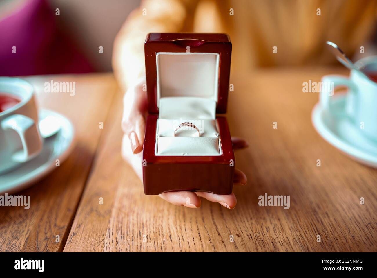 Female person hand holds box with golden wedding ring closeup view ...