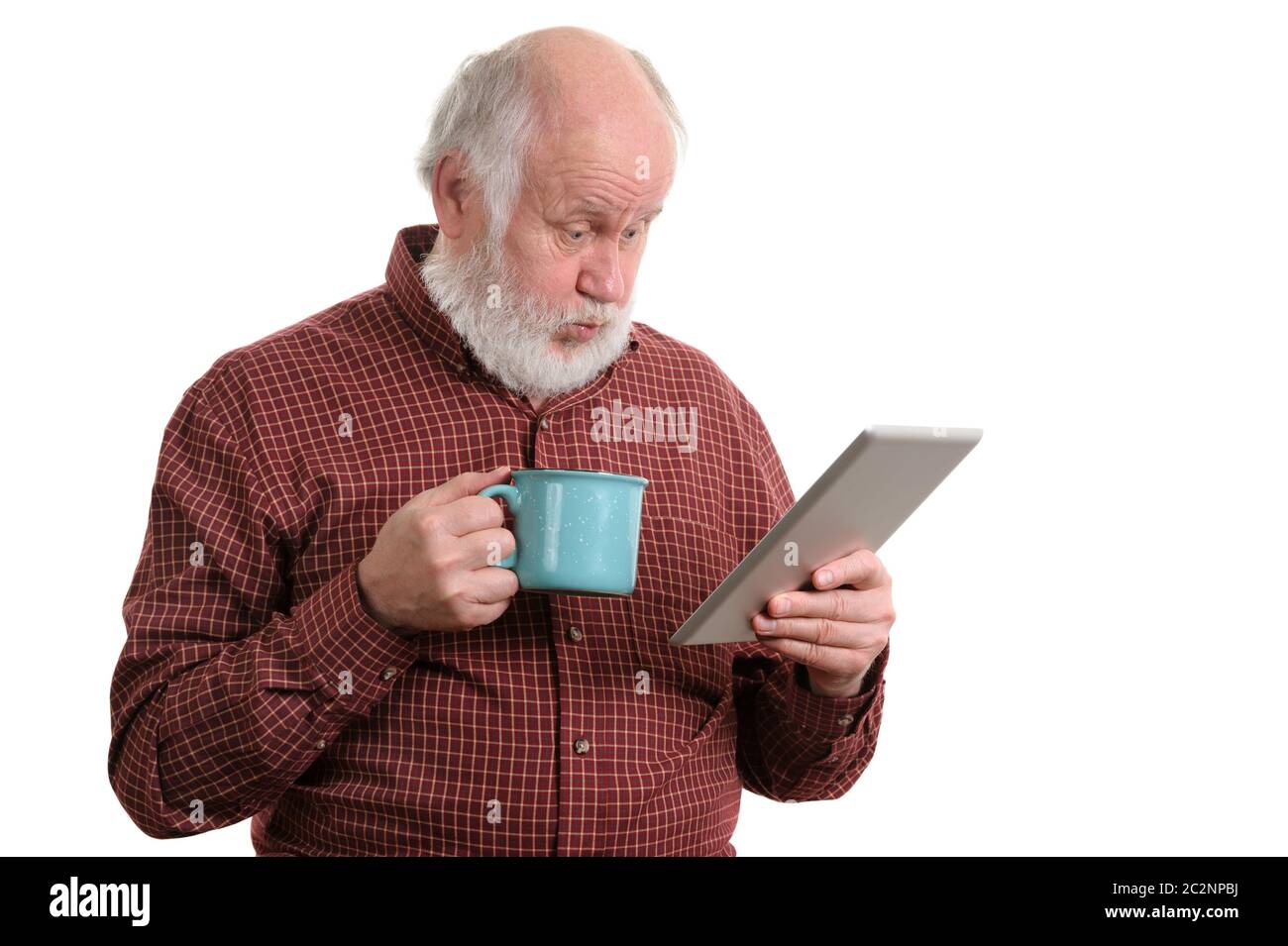 Funny shocked senior man with cup using tablet computer isolated on white Stock Photo