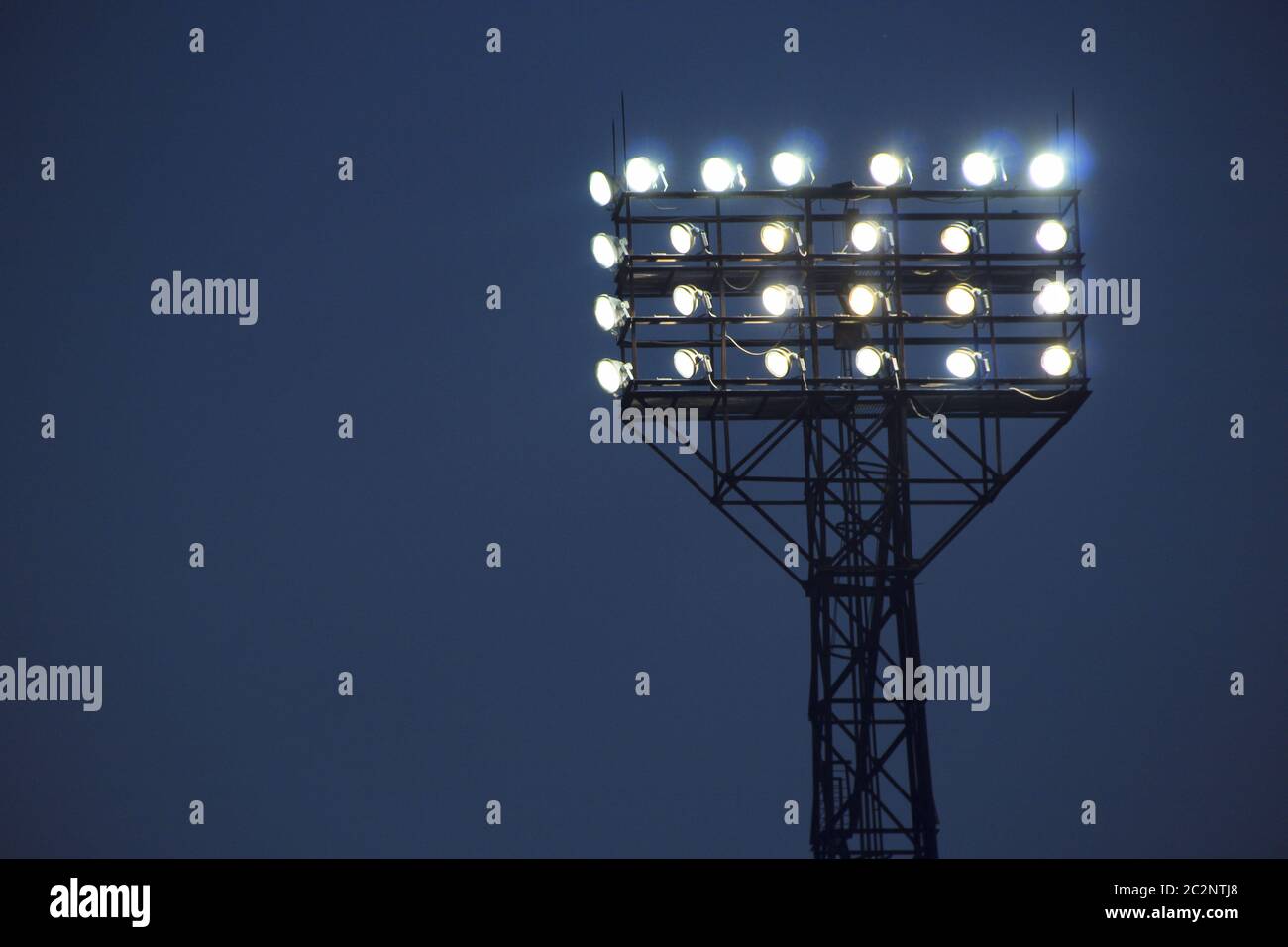 Spotlights illuminate football field during match. Lighting equipment for stadiums Stock Photo