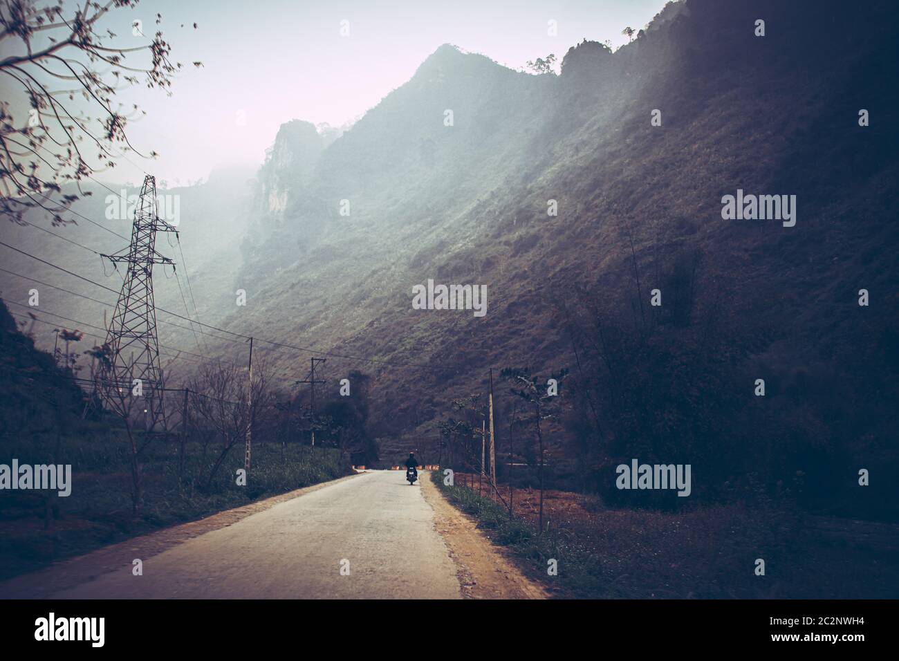 Dark and moody cinematic scenery of the fog covered mountain road in Meo vac, Ha giang Province in North Vietnam Stock Photo