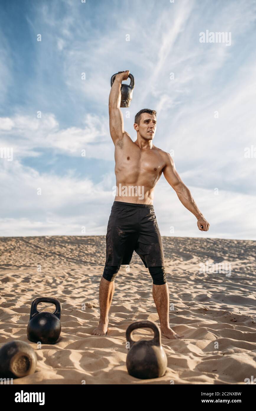 Muscular male athlete doing exercises with kettlebell in desert at sunny  day. Strong motivation in sport, strength outdoor training, sportsman with  we Stock Photo - Alamy