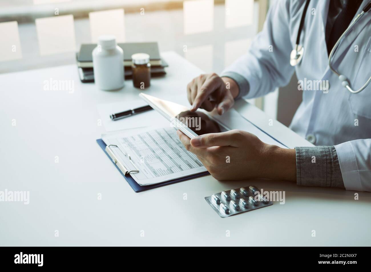 Asian doctor using the tablet explaining the patient condition and the ...