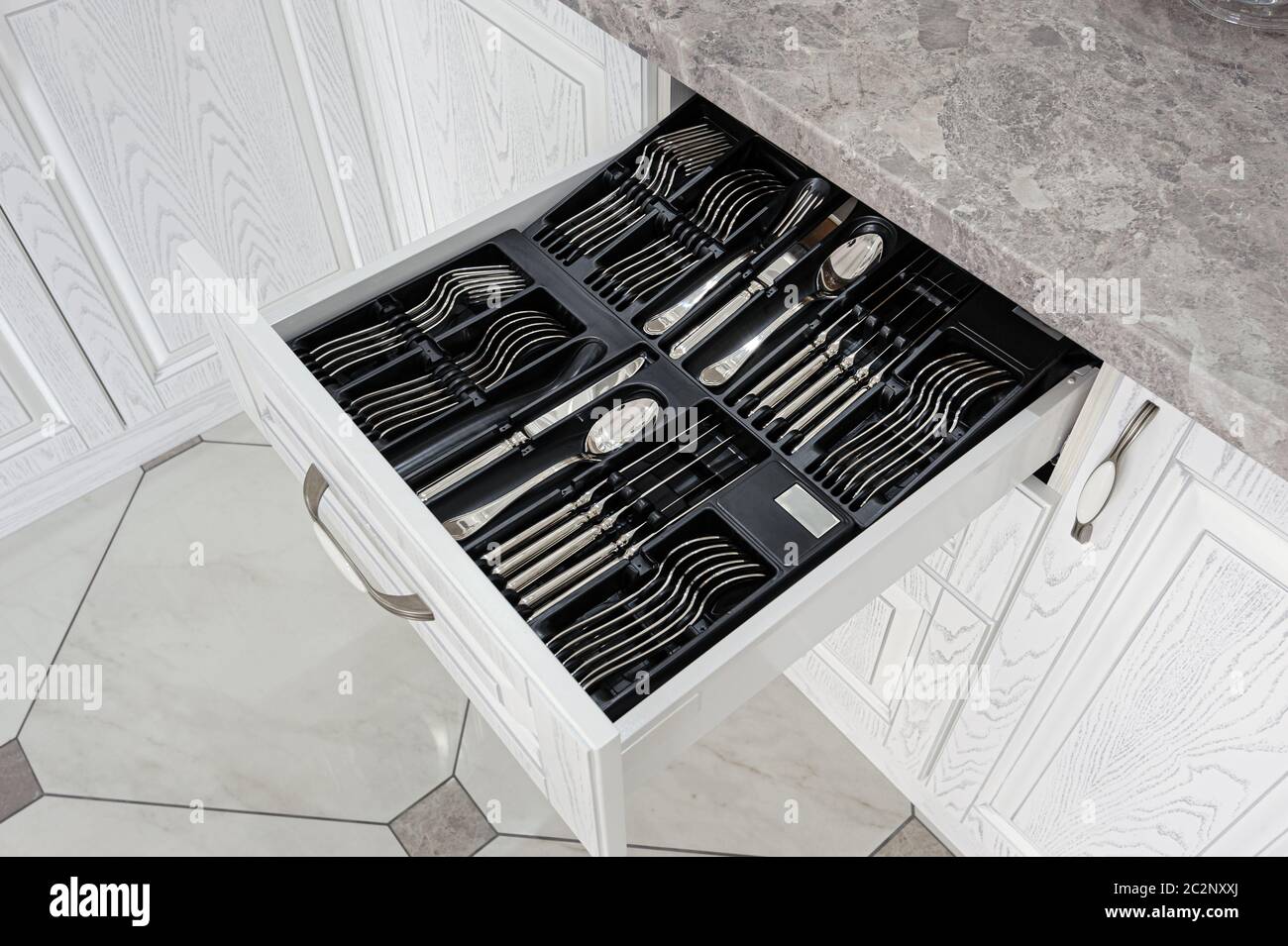 drawer with silver cutlery in modern white kitchen Stock Photo