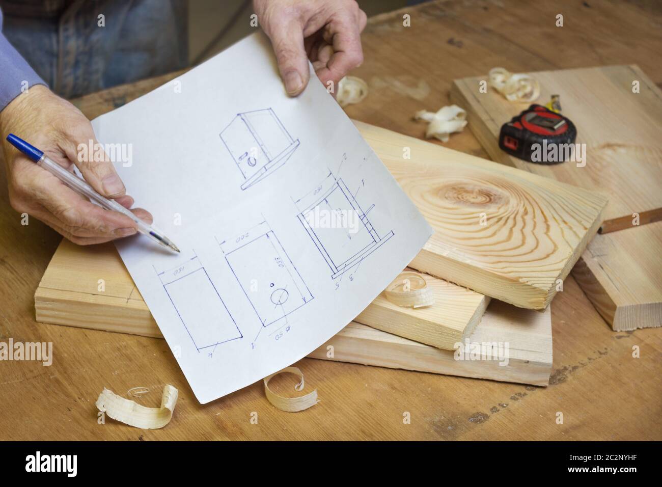 Carpenter is studying the drawing of a birdhouse Stock Photo