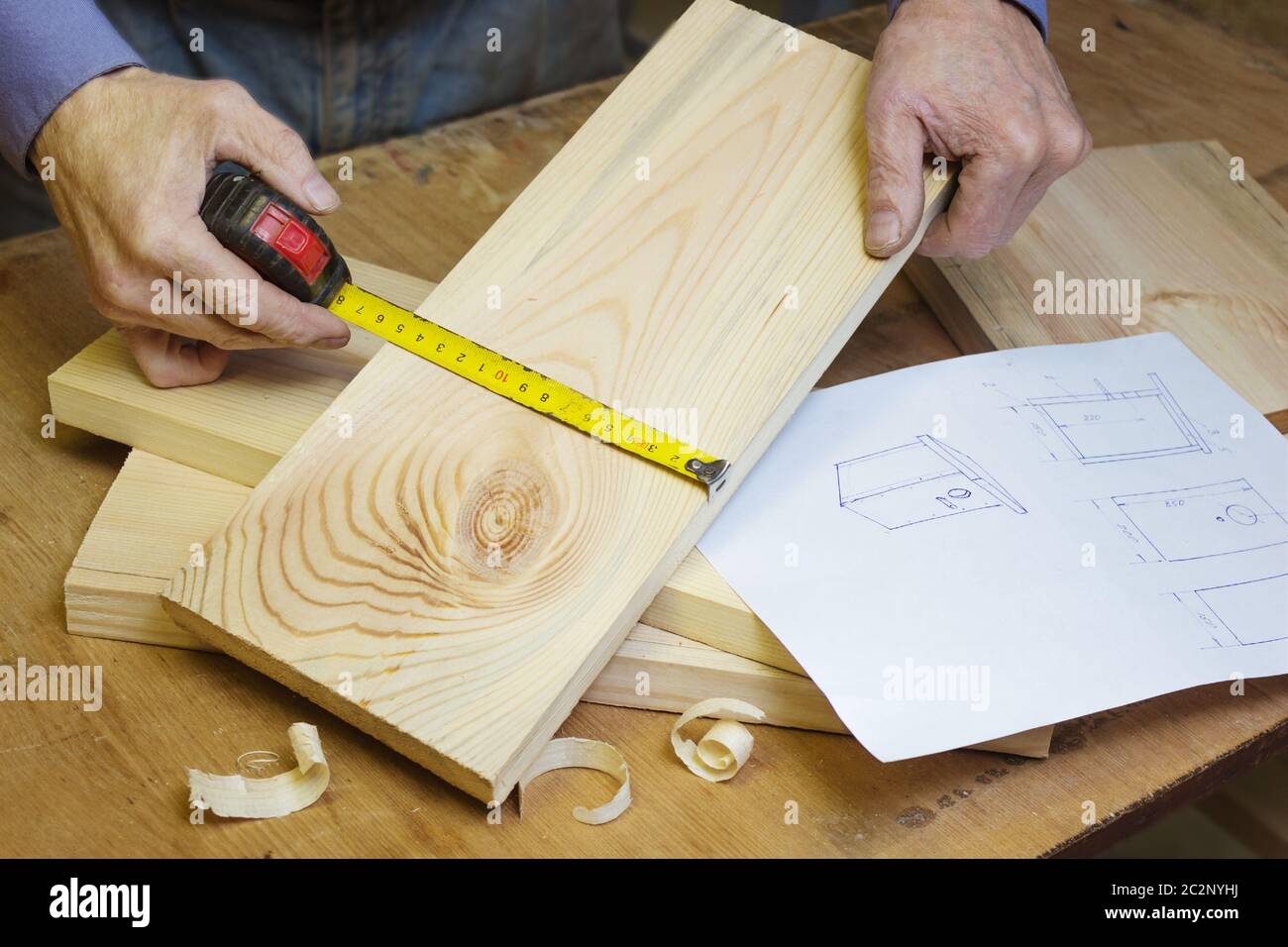 Carpenter makes a birdhouse in the workshop by sketch Stock Photo