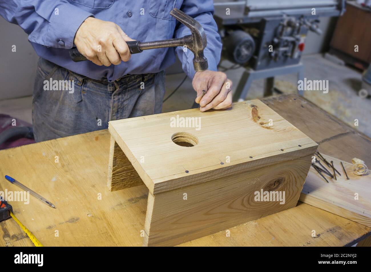 Carpenter doing assembly a birdhouse Stock Photo