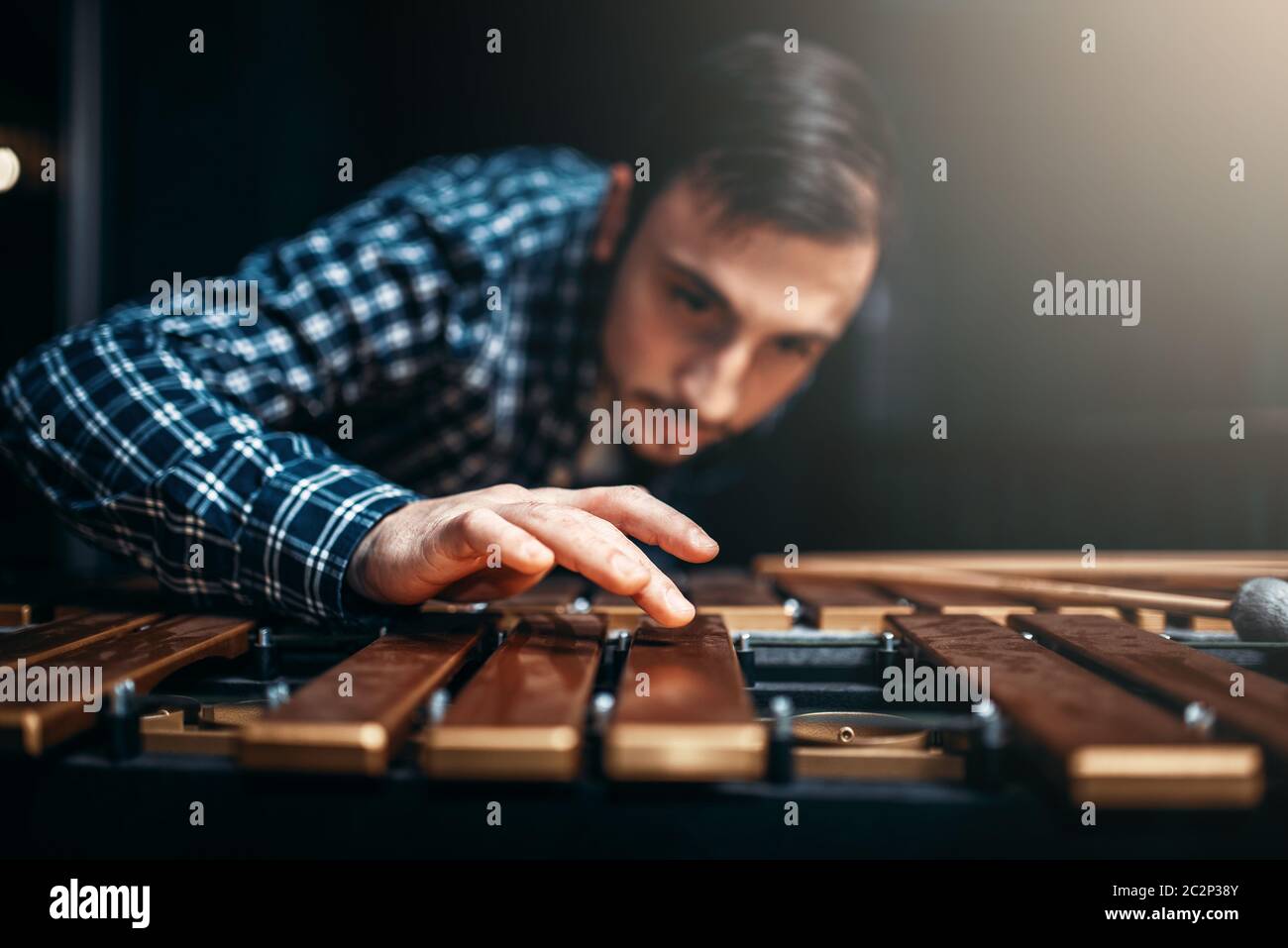 Xylophone player with sticks in hands, musician in action, wooden