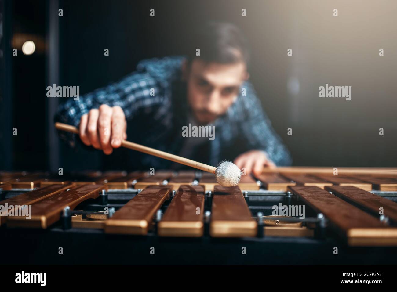 Xylophone player with sticks in hands, musician in action, wooden