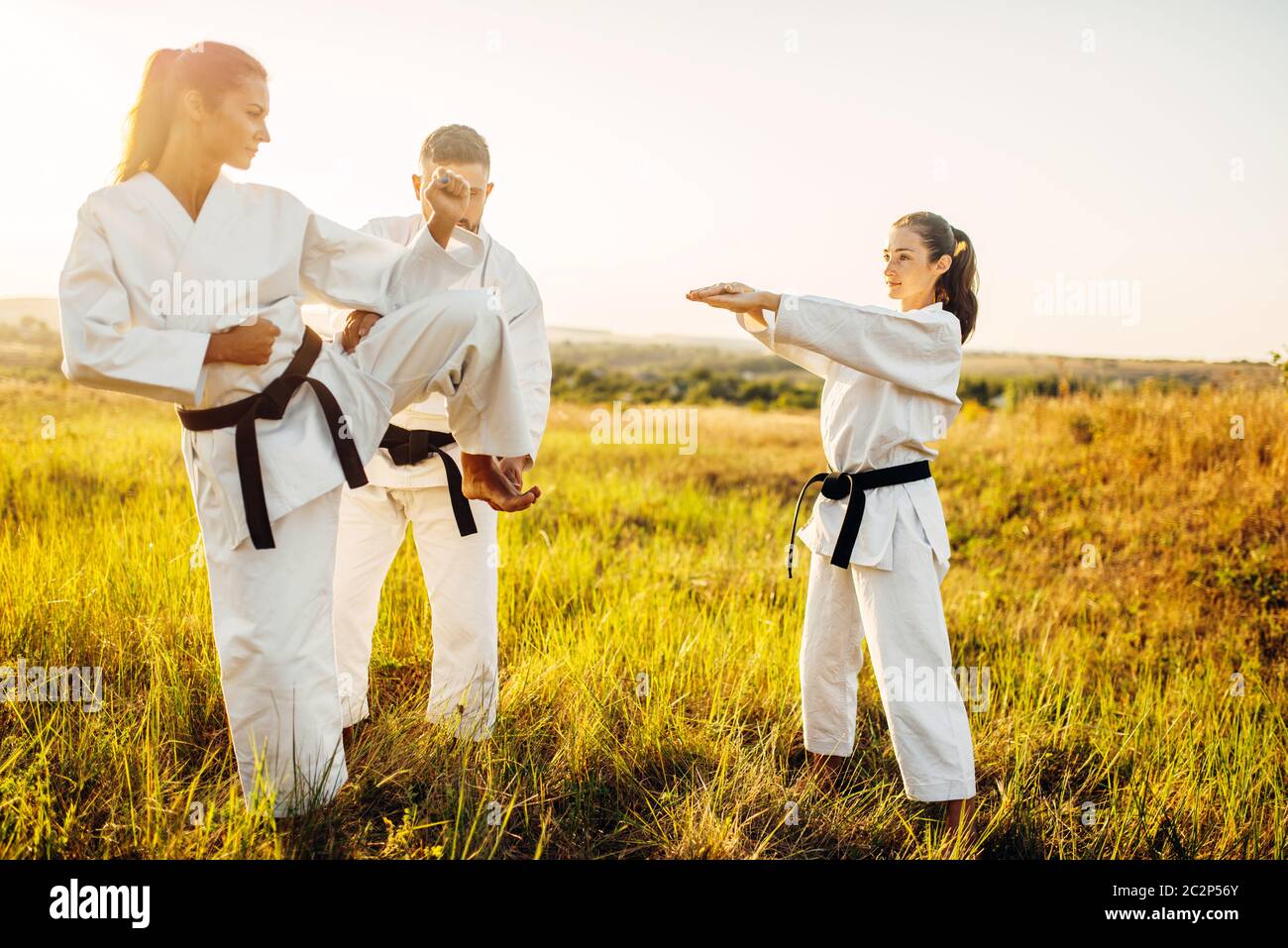 Master teaches female karate fighters the correct stand when kicking