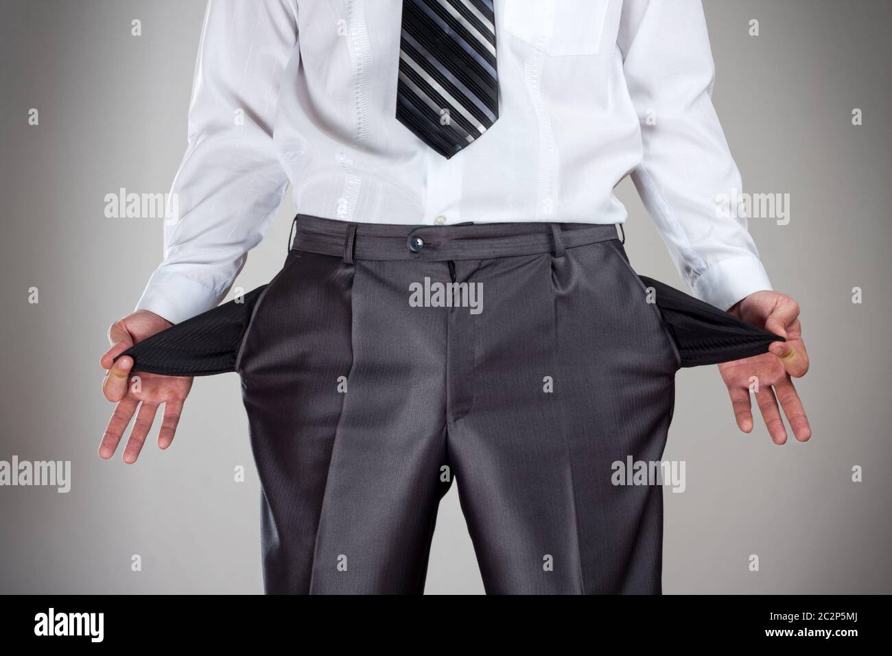 Businessman pulling empty pockets out of pants Stock Photo Alamy