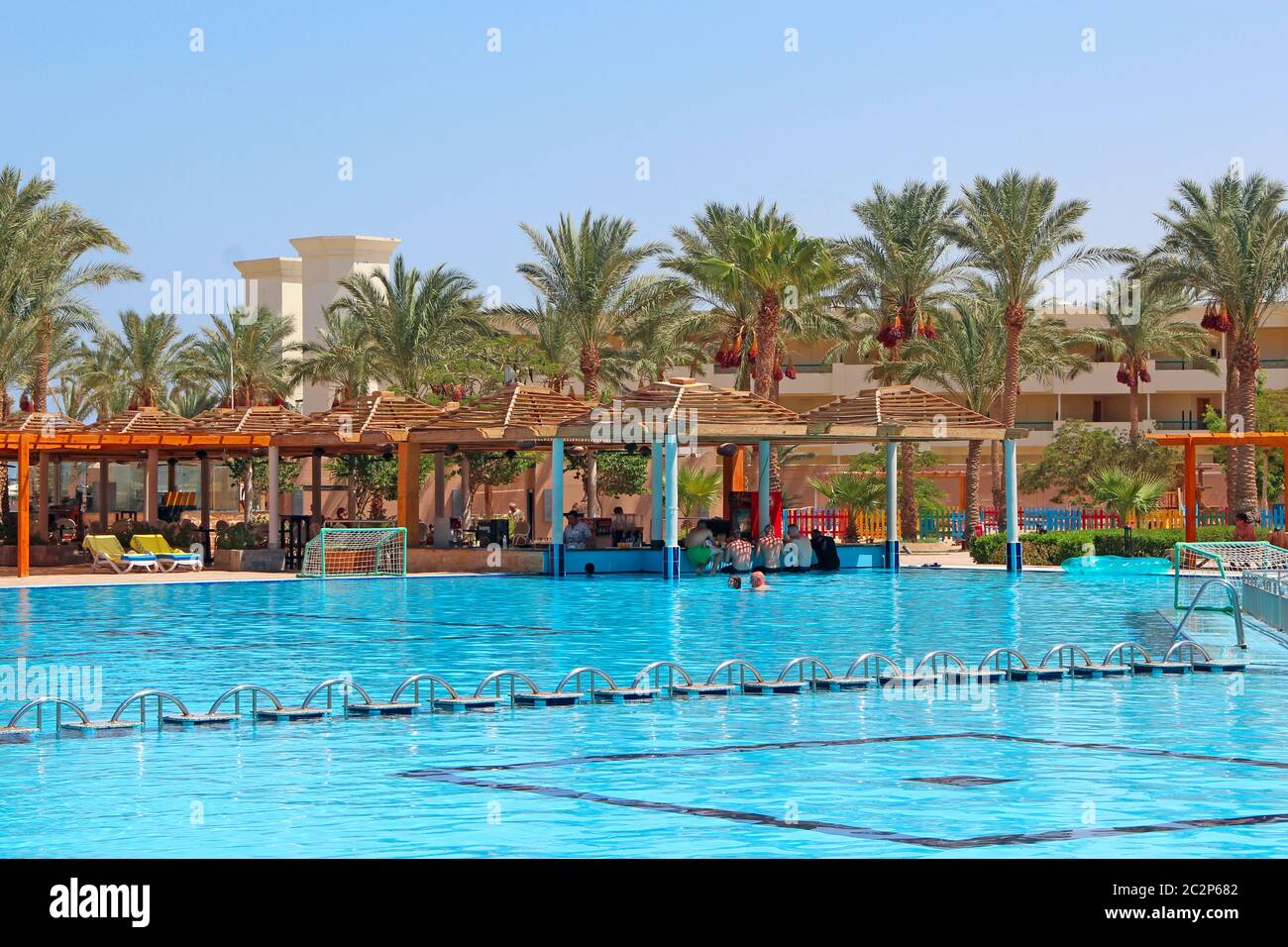 Tropical resort in Egypt. Swimming pool with light blue water palm trees and building of hotel Stock Photo