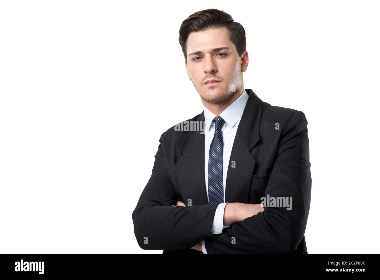 Young serious businessman in tie and black suit poses, isolated on ...