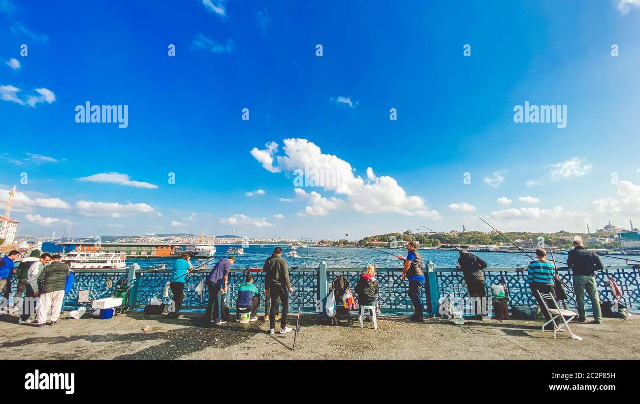 October 27, 2019 Istanbul. Turkey. Fisherman fishing on the Galata Bridge in Istanbul Turkey. People walk on Galata bridge. Vaca Stock Photo