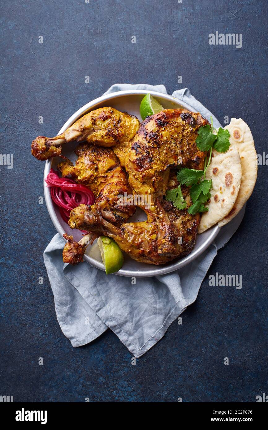 Tandoori chicken marinated in tikka served with rice naan, lime and cilantro. Indian cuisine