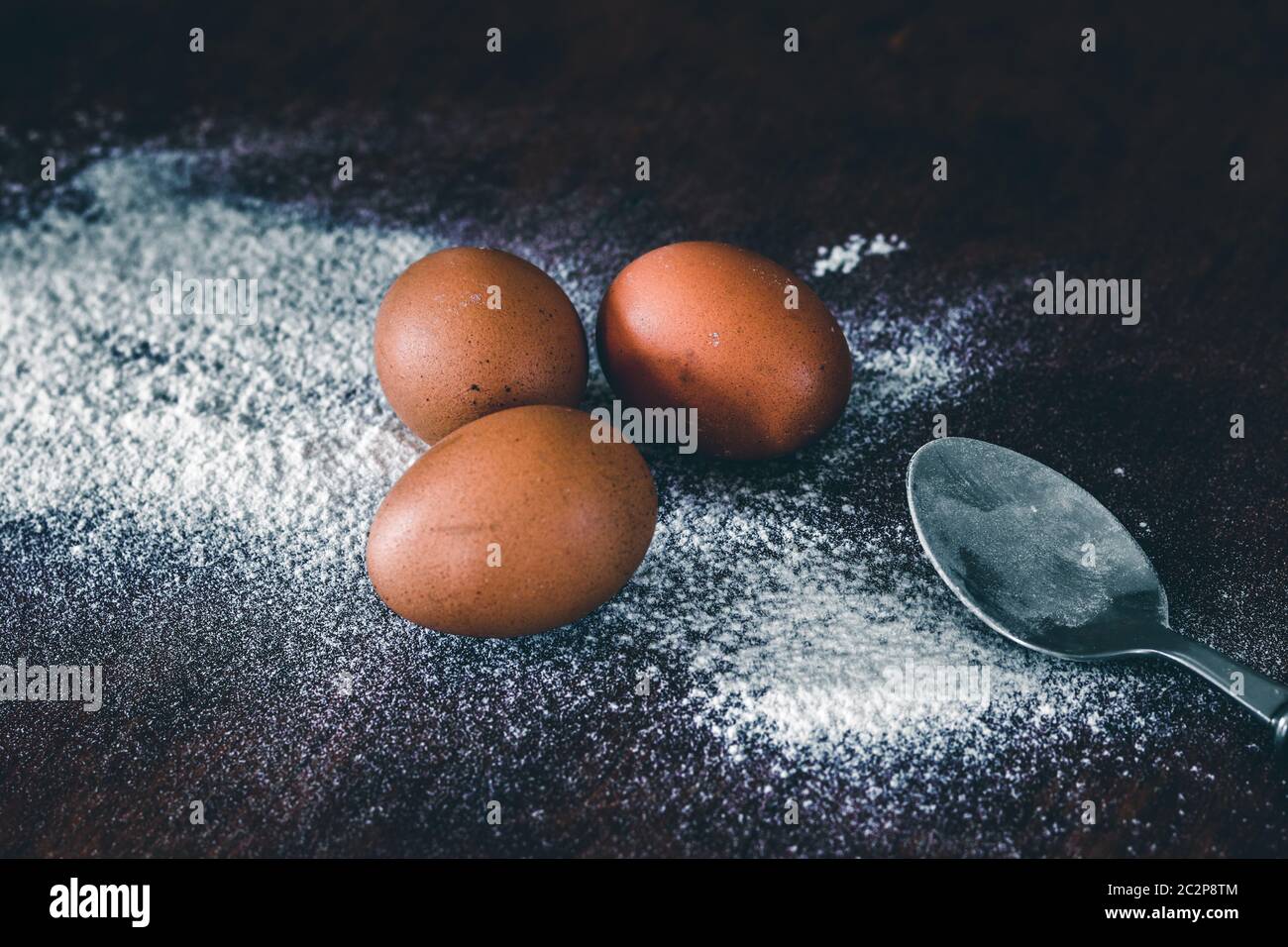 Conceptual still life photo of eggs and flour spilled on a table to show concept of baking as a way to support mental health and coping during home qu Stock Photo