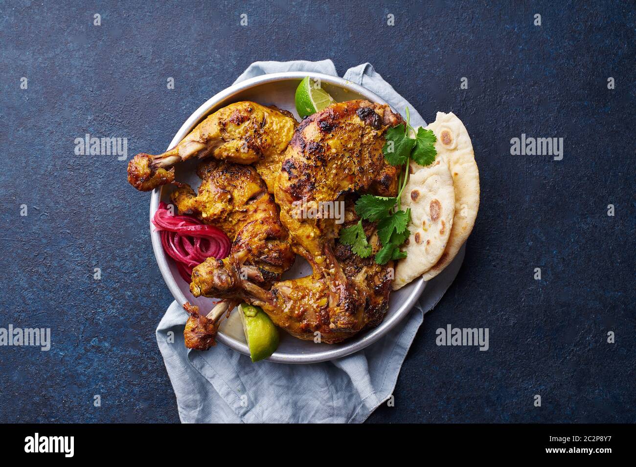 Tandoori chicken marinated in tikka served with rice naan, lime and cilantro. Indian cuisine