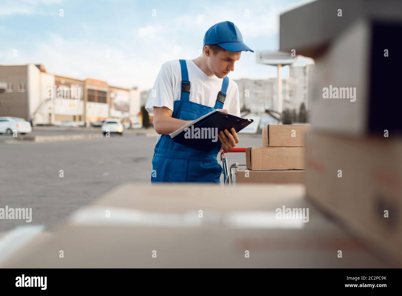 Deliveryman in uniform check parcels, delivery service. Man standing at