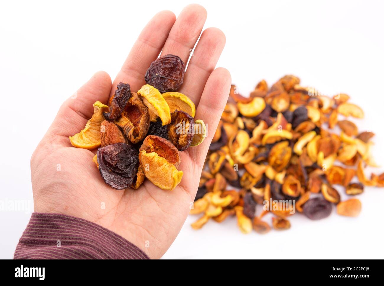 Mix of dried bits of fruits on the hand Stock Photo