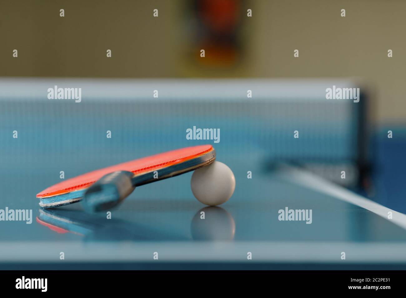 Ping pong racket and ball on game table with net, nobody, closeup view ...