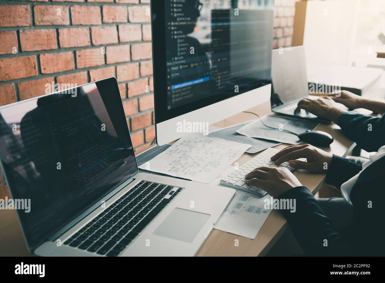 Two partnerships developing programming and coding technologies working on laptop and analyzing together. Stock Photo
