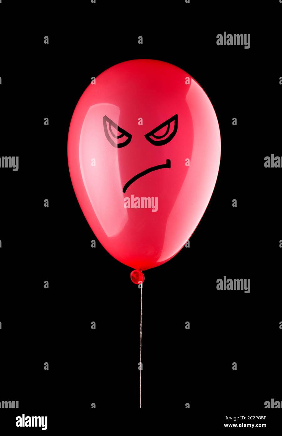 Angry red balloon isolated on black Stock Photo - Alamy