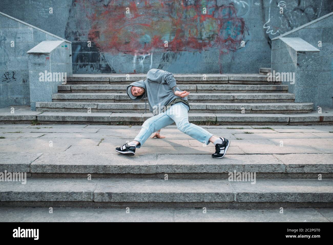Male rapper posing on the street, urban dancing. Modern dance style ...