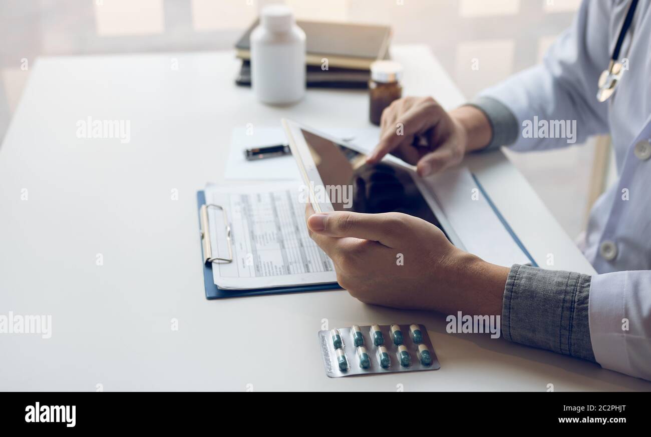 Asian doctor using the tablet explaining the patient condition and the ...