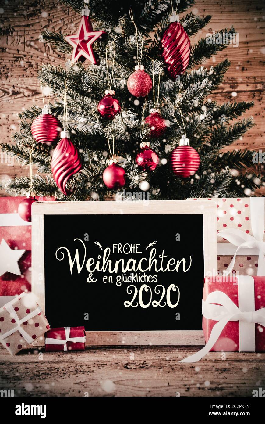 German Calligraphy Frohe Weihnachten Und Ein Glueckliches 2020 Means Merry Christmas And A Happy 2020 Christmas Tree With Gifts Red Ball Ornament An Stock Photo Alamy