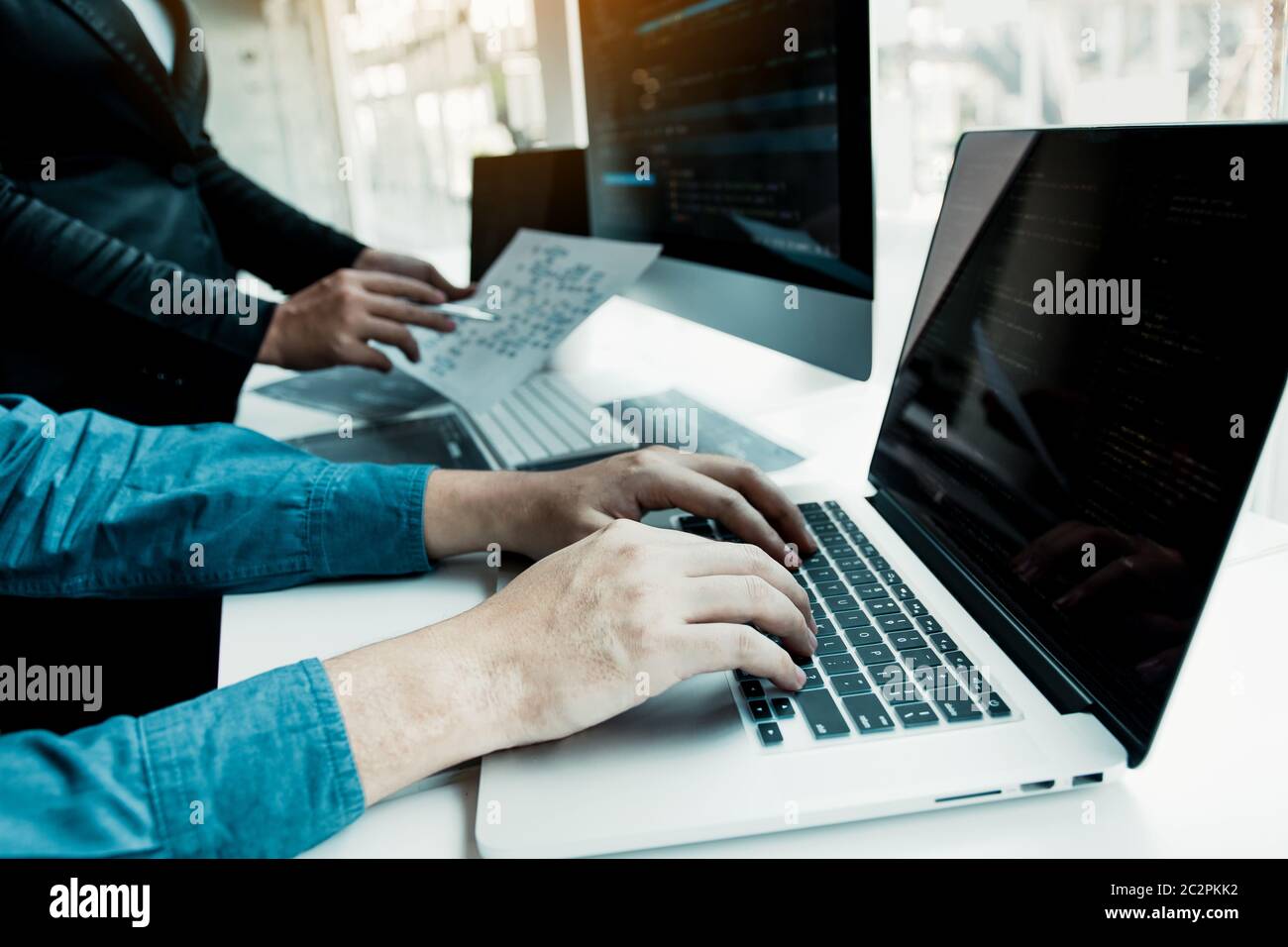 Two partnerships developing programming and coding technologies working on laptop and analyzing together. Stock Photo