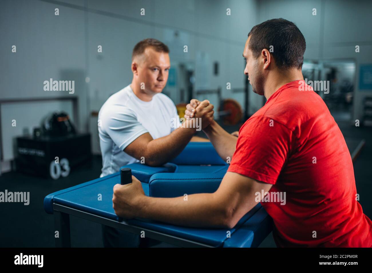 Two arm wrestlers at the table with pins, training before wrestling