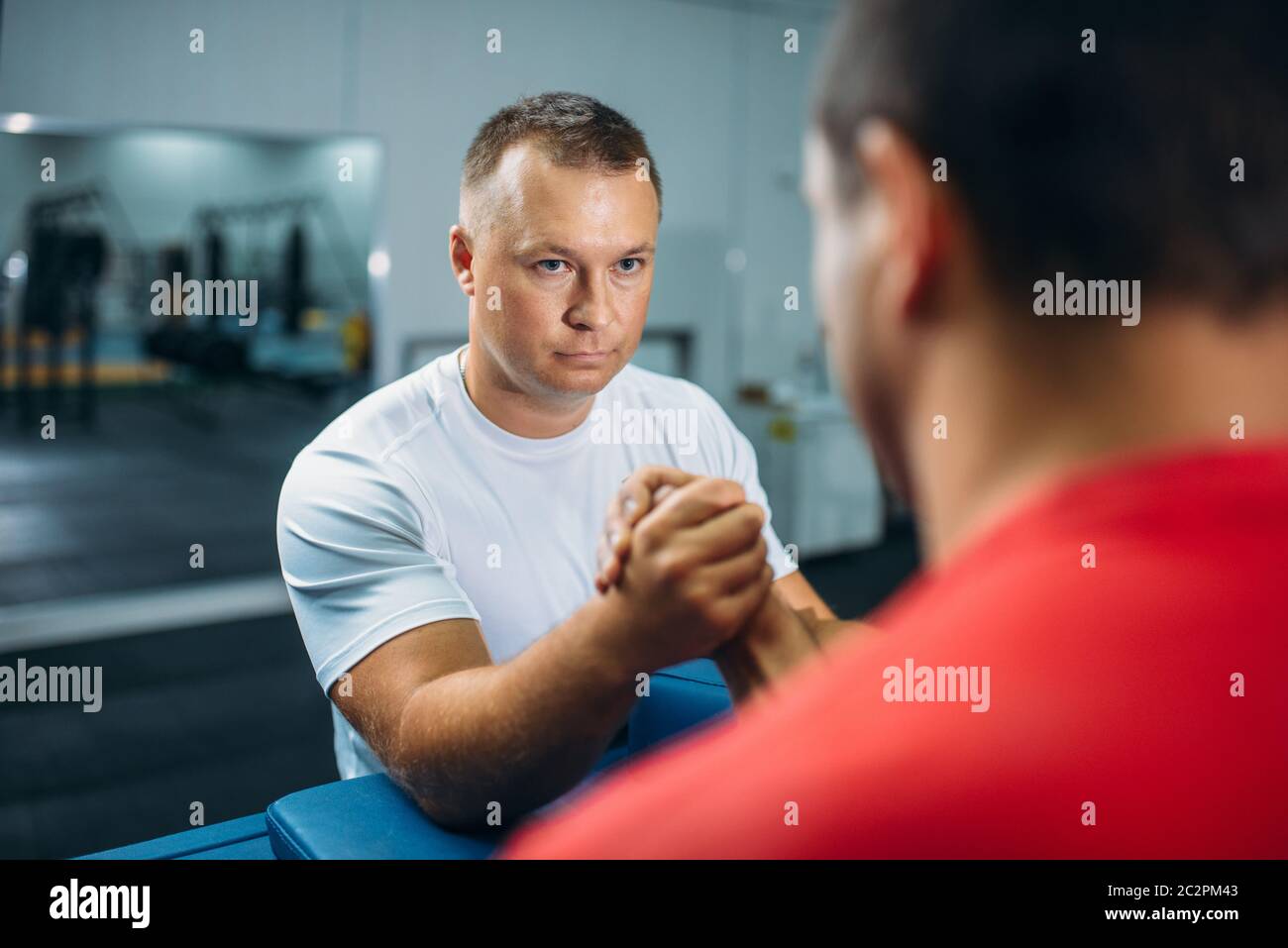 Two arm wrestlers at the table with pins, training before wrestling