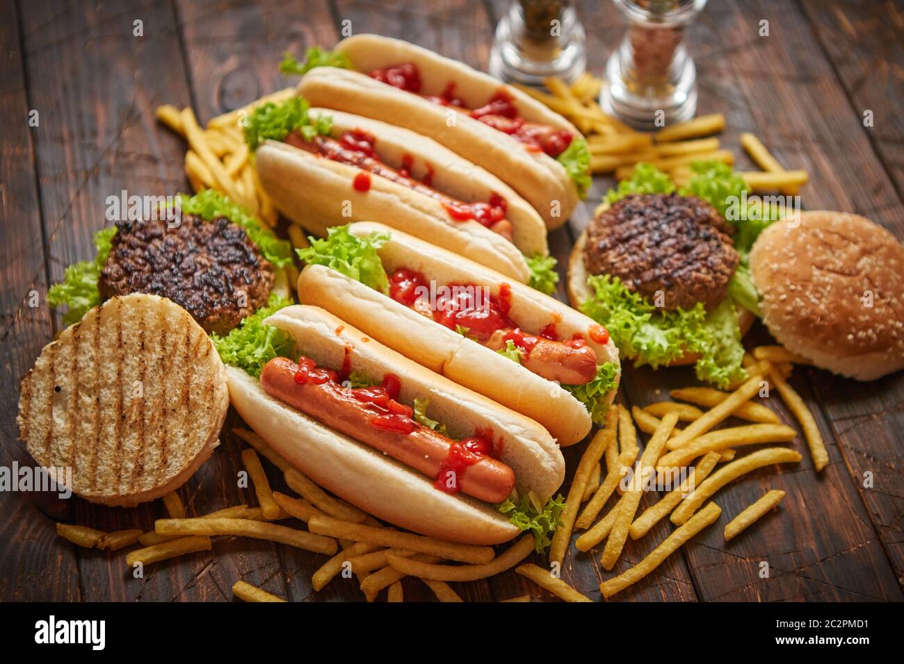 Fastfood assortment. Hamburgers and hot dogs placed on rusty wood table Stock Photo